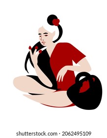 Girl in a red and black robe eats strawberries from her hand