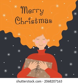 A girl with red hair is holding a gift. The inscription Merry Christmas.