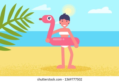 Girl with rubber circle in the form of flamingos on the beach