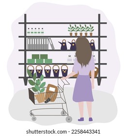 A girl is shopping in a supermarket in the gardening department. Shopping with cart near racks.