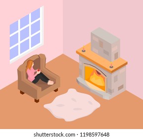 A girl sits in an armchair and warms by the fireplace. The girl in a pink sweater holds a mug of hot coffee and looks at the fireplace.