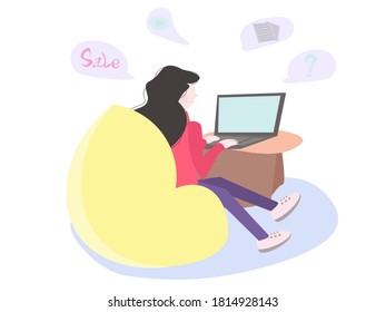The girl sits behind a laptop on a beanbag. Shopping online, reading and learning online. Social network concept.