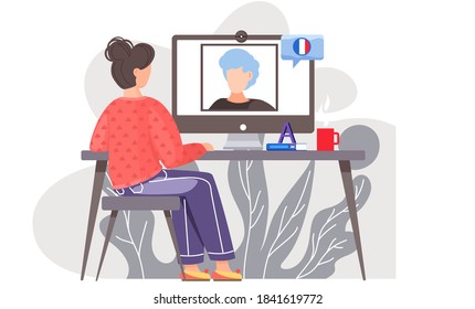 A girl sits in front of a computer monitor at lesson in French with native speaker. The teacher on screen speaks French. Foreign language lessons via the Internet. Online learning with frenchwoman