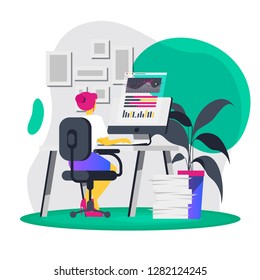 The girl sits at a table with a computer, a view from the back, examines the graphics and data on the monitor, with documents, a Secretary at work, office interior items