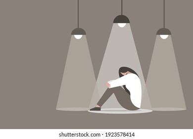 A girl sitting in the dark with spot light falling on her