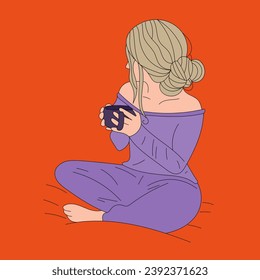 The girl is sitting and holding a mug in her hands