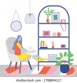 Girl sitting on a chair at home, cat in her arms