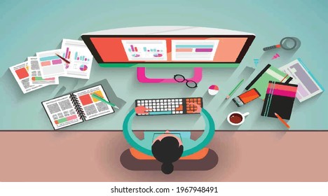 A girl sitting on a chair and using computer. other objects like books and pens etc placed on the table.