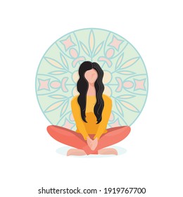 The girl is sitting on the floor. A young woman relaxes, does yoga against the background of a drawing of a mandala.