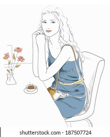 Girl sitting at a table in a cafe, drinking coffee