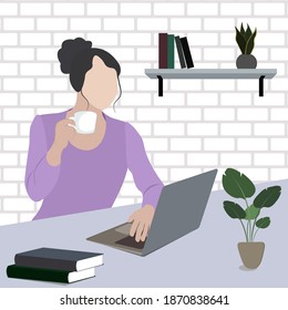 Girl sitting at a table in the office with a laptop and a cup of coffee