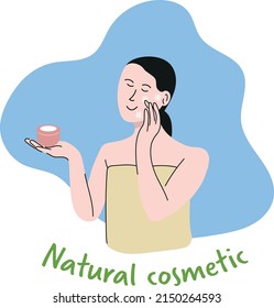 The girl smears her face with natural cream.