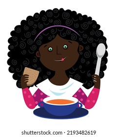 A girl with a spoon and bread in her hands in front of a plate of soup
