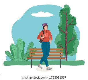 Girl in sportswear in a hat carries a backpack on her shoulder. Stylish young female chracter walking in the open air, active lifestyle. Girl teenager with short dark hair in jeans and a sweater walks