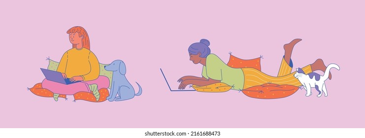 The Girl Studies Online Lying On Pillows With A Cat At Her Feet. Woman Working On A Laptop While Sitting On Pillows At Home With A Dog. Remote Work And Study.