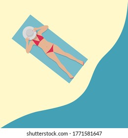 A girl is sunbathing on the beach. A girl in a hat is sunbathing on the beach. A girl in a red swimsuit is sunbathing on the beach.