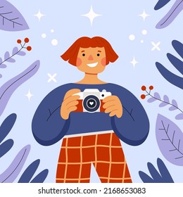 Girl taking a photo. Redheaded smiling female photographer holding a camera. Blue floral background, leaves and flowers. World phorography day. Flat hand drawn cartoon vector illustration