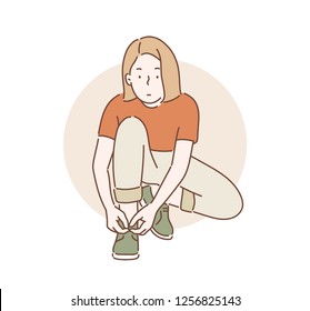 A girl is tying her shoelace. hand drawn style vector design illustrations.