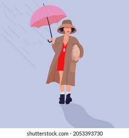 A girl with an umbrella and a package in her hands walks in a raincoat