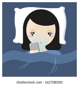 Girl using Mobile Phone While Lying Under Blanket On The Bed before bedtime.The blue light has a negative effect on eyes.