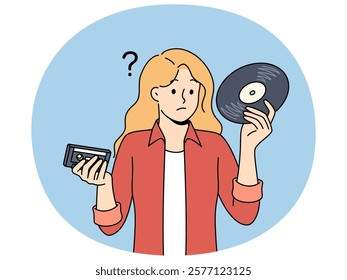 Girl with vinyl record and tape cassette looks confusedly at old-fashioned storage media with music. Woman feels confused and doesn know how to listen to music stored on vintage storage devices.