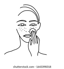 Girl washes makeup and cleanses her face with a cotton pad. Health and beauty.