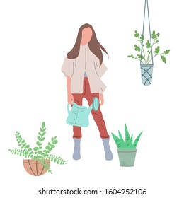 Girl watering flowers in a pot. Creating favorable conditions in a greenhouse, room or public premises for growing indoor plants.
