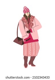 A girl in winter clothes goes for a walk on business and shopping. A woman in a winter coat with a fur collar, a wool skirt, a knitted hat, a long sweater and high boots. Fashionable daily image.