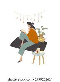 Girl woman lady reading at home house sitting on sofa couch wearing home clothes domestic clothing dress outfit wear, with candles on coffee table end table