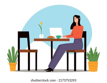 A girl works at a computer in a cafe.