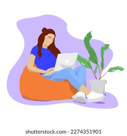 The girl works on a computer in a bag chair. Study and work at home. Woman at work. The woman is studying. Online learning. Freelance.