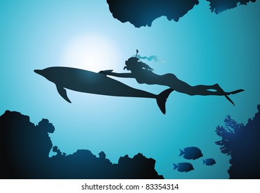 The girl-diver floats together with a dolphin among reeves
