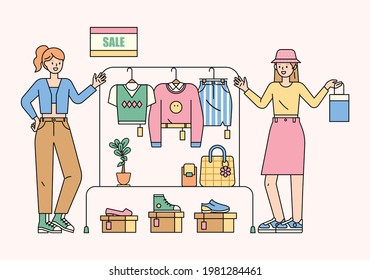 Girls are choosing fashion items and clothes in the sale section. flat design style minimal vector illustration.