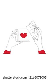 
The girl's hands open a gift box with a red heart inside. 
Two hands holding and open the gift box.