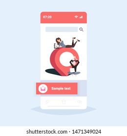 Chicas que trabajan en la computadora portátil usando el App de navegación Geo Pin Tag Pointer Mujeres Pareja con marcador de ubicación Concepto de posición GPS Pantalla de teléfono inteligente Aplicación móvil