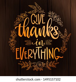 Give Thanks in Everything - quote. Thanksgiving dinner theme hand drawn lettering phrase. Logo, text design. Pumpkin, leaves, cotton design.  Orange text on dark wood background. 