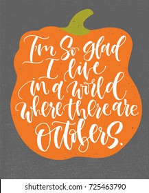 I'm so glad I live in a world where there are Octobers. Handwritten calligraphy quote and autumn motives with orange pumpkin on background. Poster or greeting card.