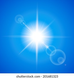 Glaring sun with lens flare over blue background