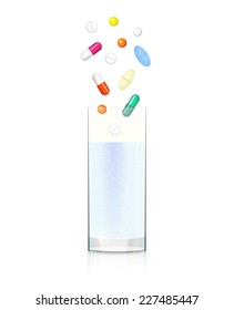 Glass with clear liquid and different pills and capsules