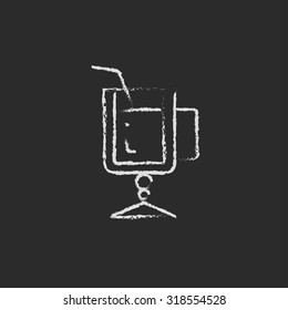 Glass with drinking straw hand drawn in chalk on a blackboard vector white icon isolated on a black background.