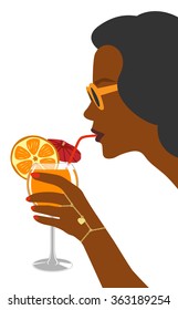 A glass of fresh orange juice in the hand of the woman