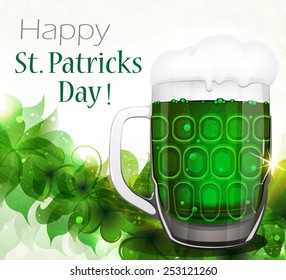 Glass of green beer with white foam on clover background.  St. Patrick's Day abstract background.