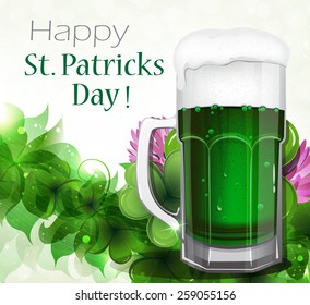 Glass of green beer with white foam on clover background.  St. Patrick's Day abstract background.