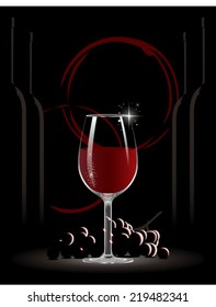 Glass of red wine surrounded by grapes and wine bottles 