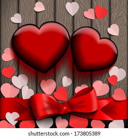 Glass Valentine hearts on wood background.