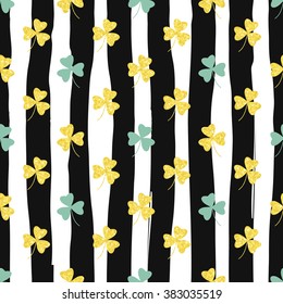 Glittering gold clover seamless pattern on striped background. Seamless background for greeting card for St. Patrick's day. Recurring pattern of clove flower -  sign of the St. Patrick's day. eps