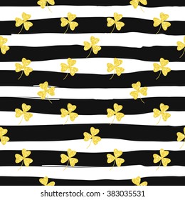 Glittering gold clover seamless pattern on striped background. Seamless background for greeting card for St. Patrick's day. Recurring pattern of clove flower -  sign of the St. Patrick's day. eps