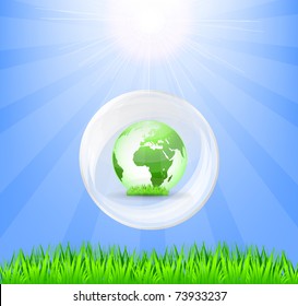Globe in white crystal, green grass and sun