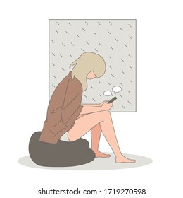 Gloomy girl texting on her phone in rainy day