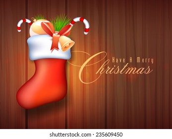 Glossy elegant Santa stocking full of X-mas ornaments for Merry Christmas celebration on wooden background.